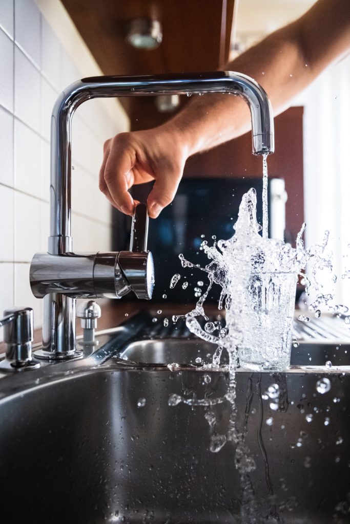 water coming out of the sink into a glass